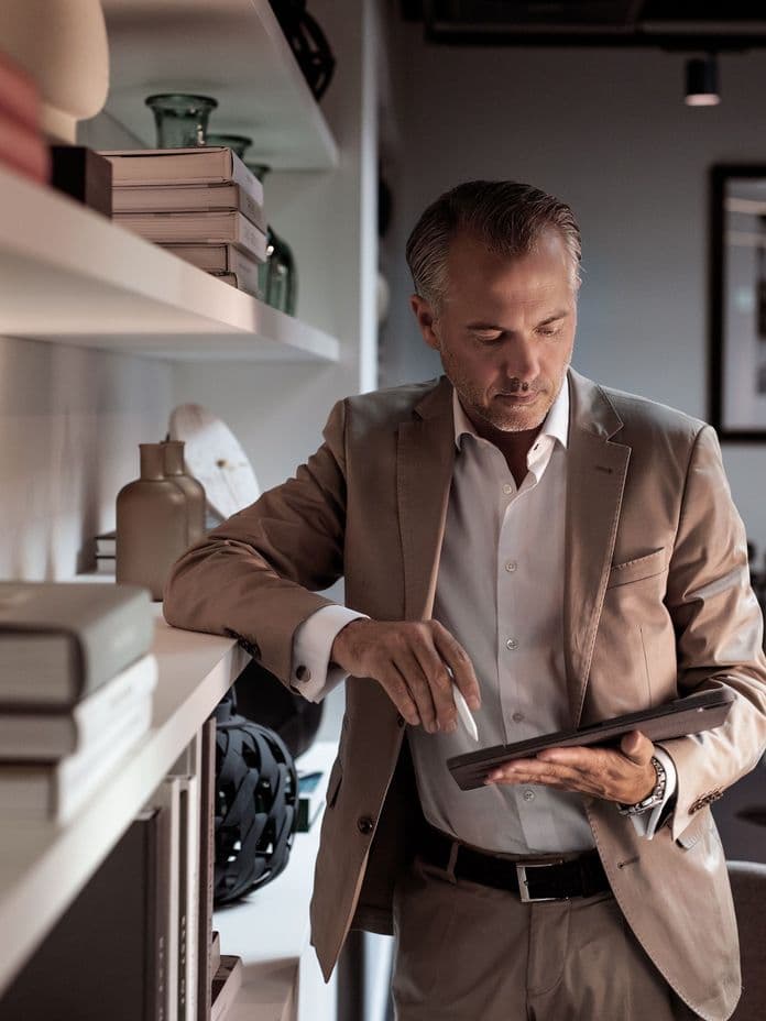 Geschäftsmann arbeitet entspannt mit iPad in modernem Coworking Space